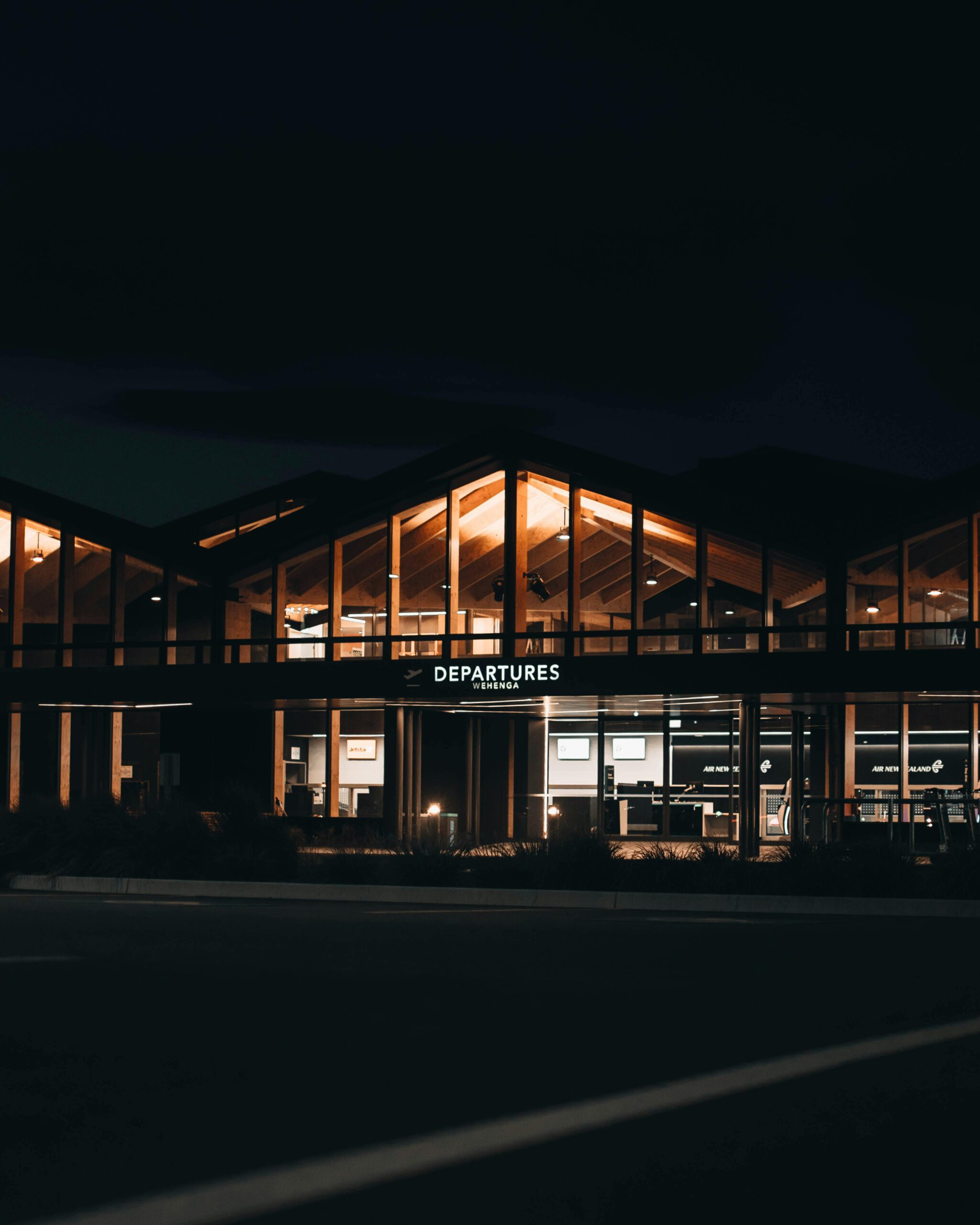 Illuminated airport departures at night, showcasing modern architecture in Nelson, New Zealand.